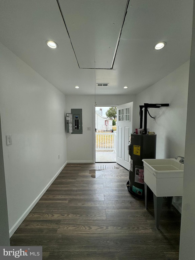 interior space with sink, electric water heater, dark hardwood / wood-style floors, and electric panel