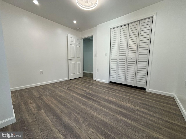 unfurnished bedroom featuring dark hardwood / wood-style floors and a closet