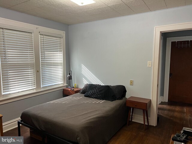 bedroom featuring dark wood-style floors and baseboards