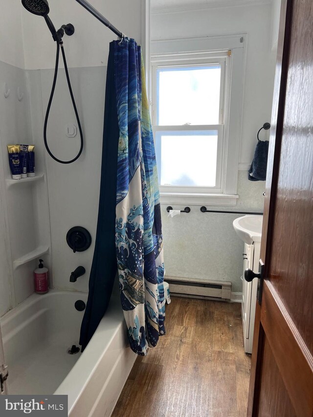 bathroom featuring a baseboard heating unit, vanity, wood finished floors, and shower / tub combo with curtain