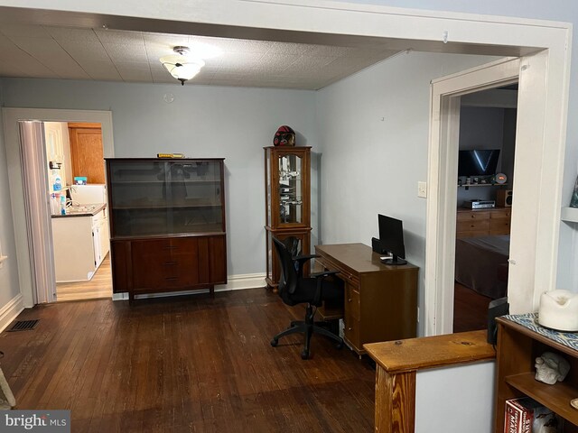 office featuring hardwood / wood-style floors, baseboards, and visible vents