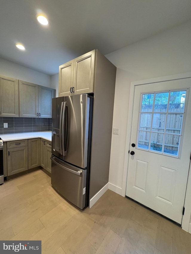 kitchen with tasteful backsplash, light wood-type flooring, and appliances with stainless steel finishes