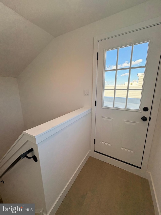 doorway to outside featuring dark hardwood / wood-style flooring and lofted ceiling