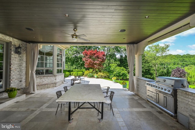 view of patio with area for grilling, ceiling fan, and a grill