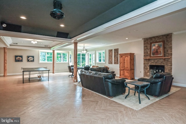 living room featuring a fireplace, light parquet flooring, a raised ceiling, and ornamental molding