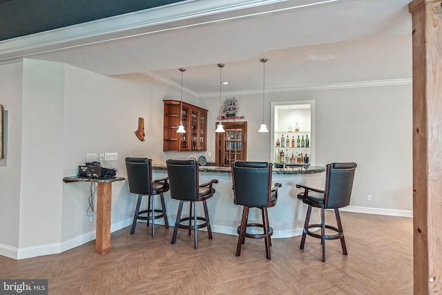 kitchen with hanging light fixtures, parquet flooring, ornamental molding, a kitchen bar, and kitchen peninsula