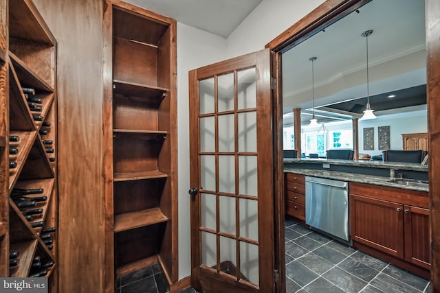 interior space featuring ornamental molding, sink, decorative light fixtures, dark stone countertops, and dishwasher