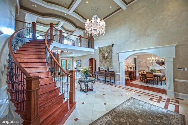 entrance foyer featuring coffered ceiling, crown molding, ornate columns, a towering ceiling, and beam ceiling