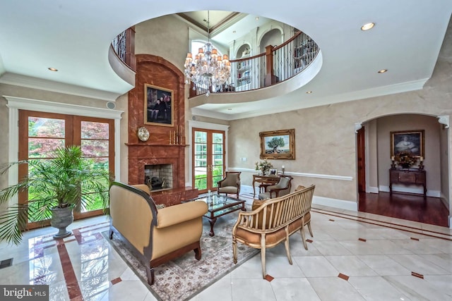 interior space with a large fireplace, a notable chandelier, a healthy amount of sunlight, and crown molding