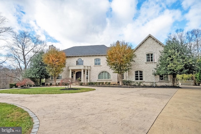 french provincial home with a front lawn