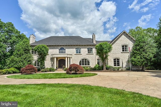 french country style house with a front lawn