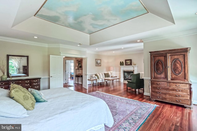 bedroom featuring a raised ceiling, multiple windows, crown molding, and dark wood-type flooring