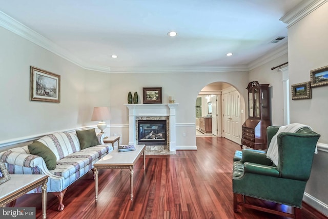 living room with a high end fireplace, hardwood / wood-style floors, and crown molding