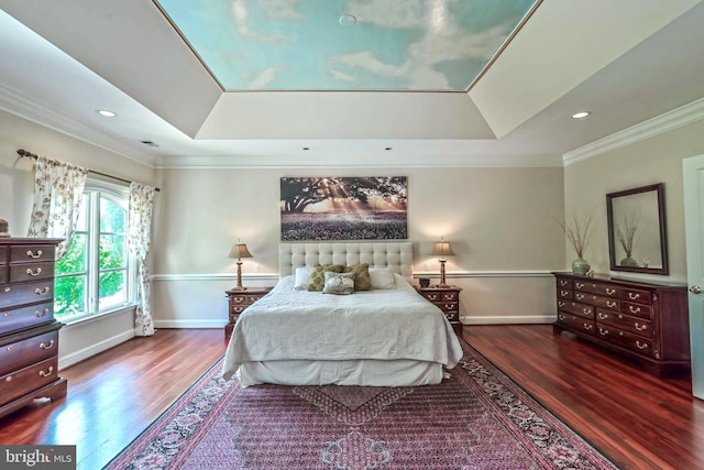 bedroom featuring dark hardwood / wood-style floors, a tray ceiling, and ornamental molding