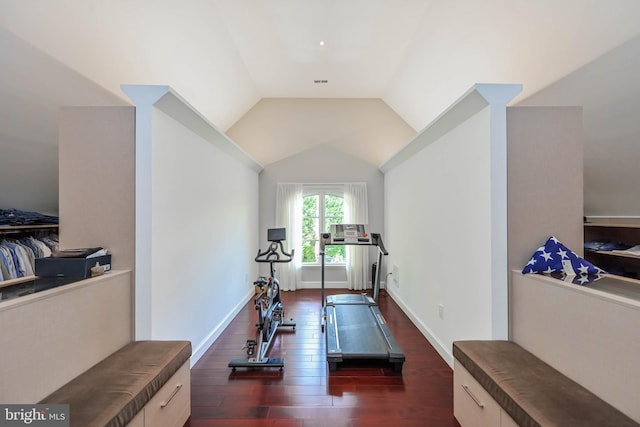 workout room featuring dark hardwood / wood-style flooring and vaulted ceiling