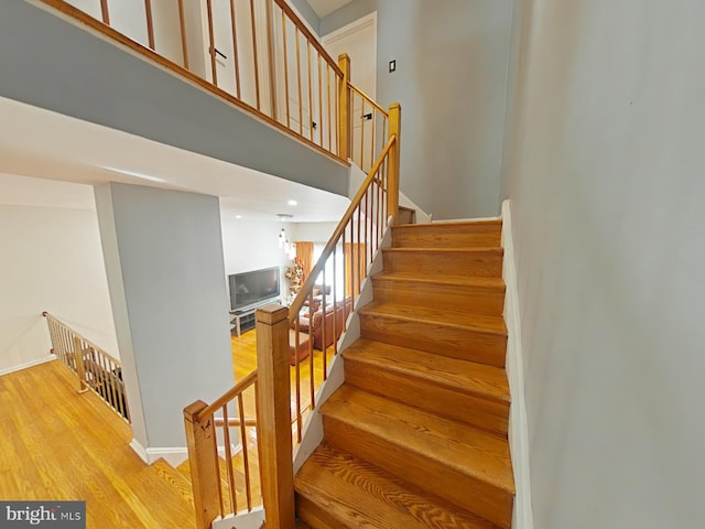 staircase featuring hardwood / wood-style flooring and a notable chandelier