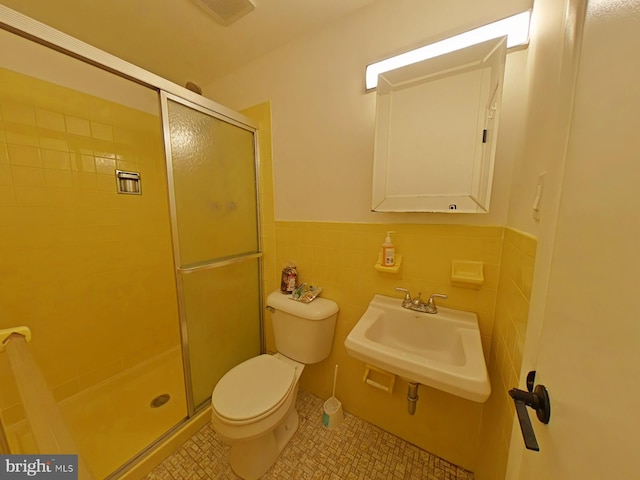 bathroom featuring tile walls, walk in shower, sink, and toilet