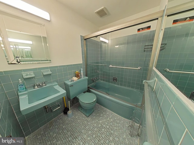 full bathroom with enclosed tub / shower combo, toilet, tile walls, tile patterned flooring, and sink