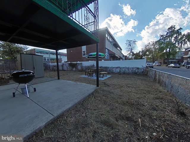 view of yard featuring a storage unit and a patio