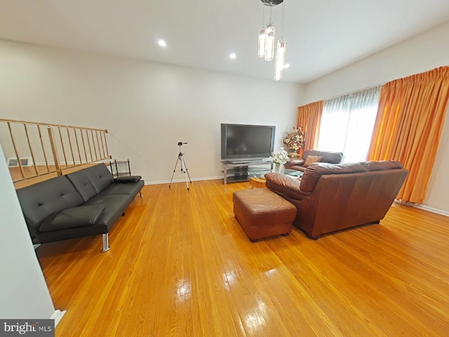 living room featuring wood-type flooring and a notable chandelier