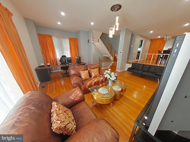 living room featuring light wood-type flooring and an inviting chandelier