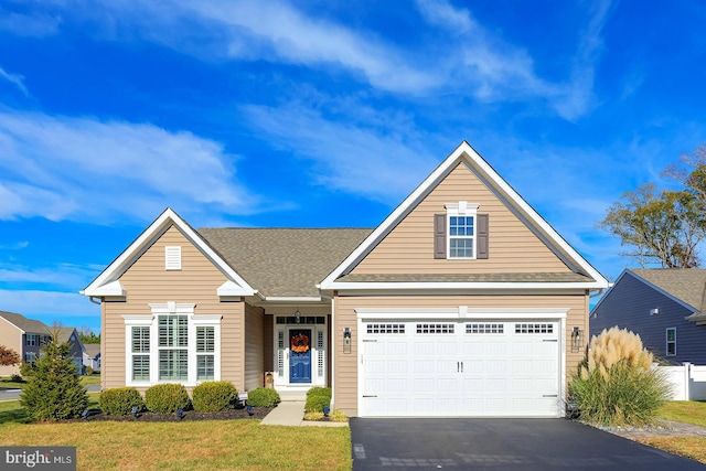 view of front of home with a front yard and a garage