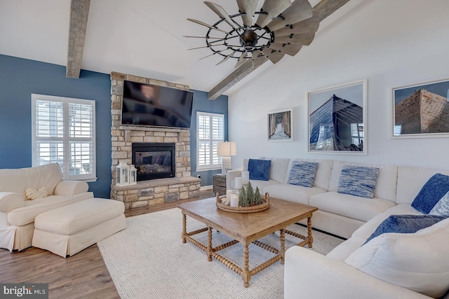 living room featuring hardwood / wood-style flooring, vaulted ceiling with beams, and a fireplace