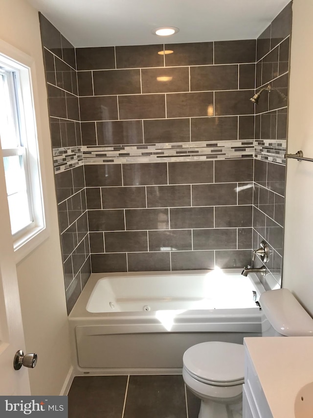 full bathroom with toilet, tiled shower / bath, tile patterned floors, and vanity