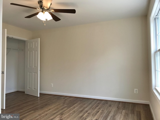 unfurnished bedroom featuring dark wood-type flooring, ceiling fan, and a closet