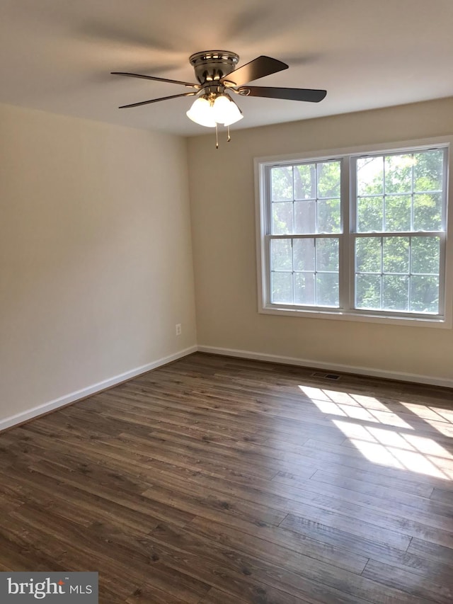 unfurnished room with ceiling fan and dark hardwood / wood-style flooring