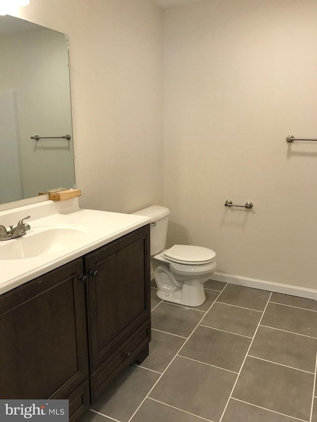 bathroom featuring toilet, vanity, and tile patterned floors