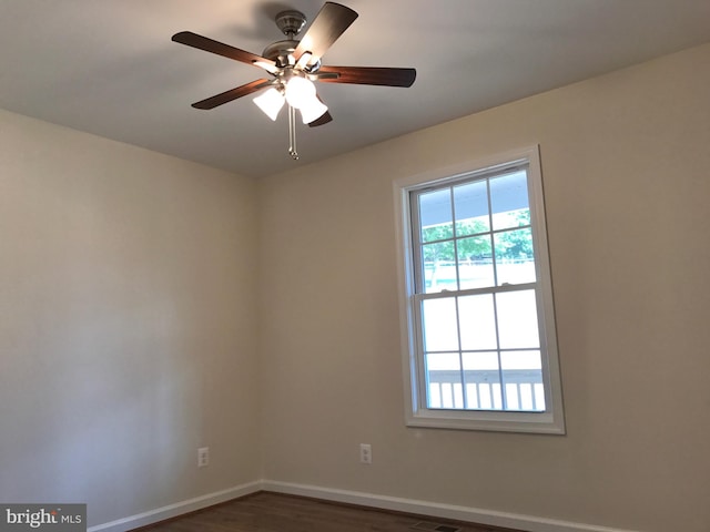 empty room featuring dark wood-type flooring and ceiling fan