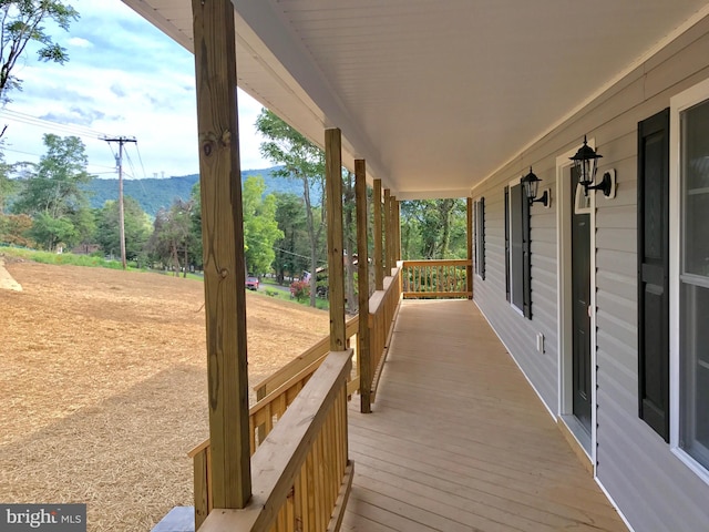 deck featuring a mountain view and covered porch