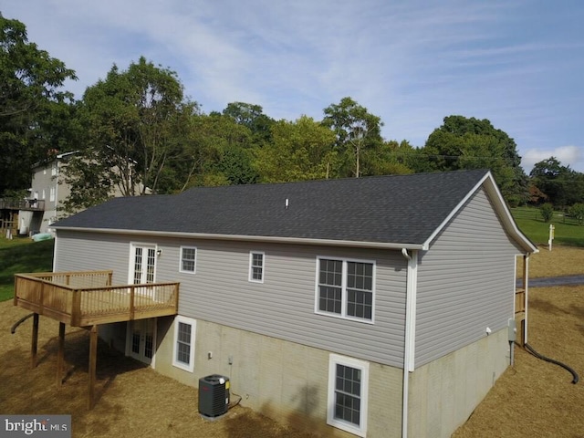 back of house with central AC unit and a wooden deck