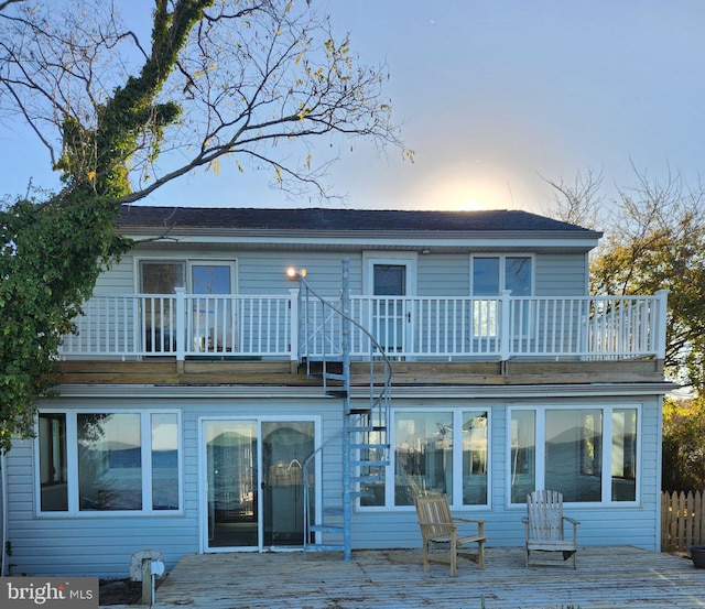 back house at dusk with a balcony