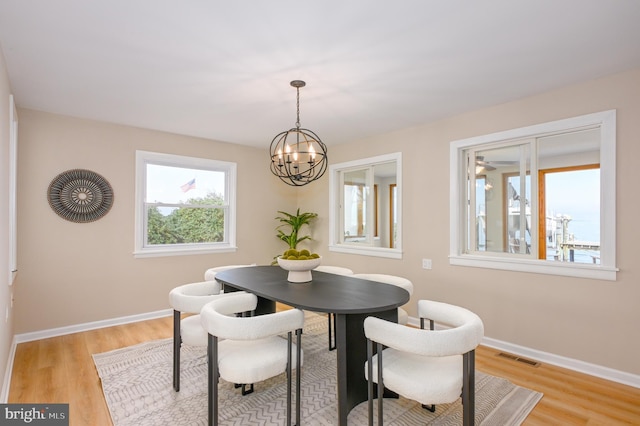 2142 Lake Dr, Pasadena, MD 21122 - dining area with a chandelier, light wood-type flooring, and baseboards