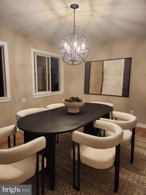 dining space featuring hardwood / wood-style floors and a chandelier