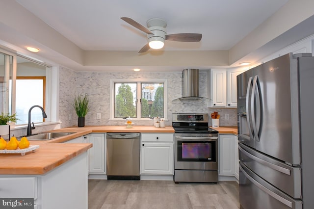 2142 Lake Dr, Pasadena, MD 21122 - kitchen featuring stainless steel appliances, wall chimney exhaust hood, butcher block countertops, and a sink