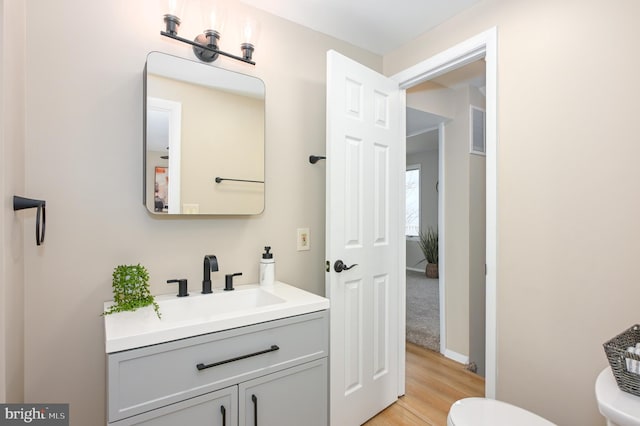 bathroom featuring hardwood / wood-style floors, vanity, and toilet