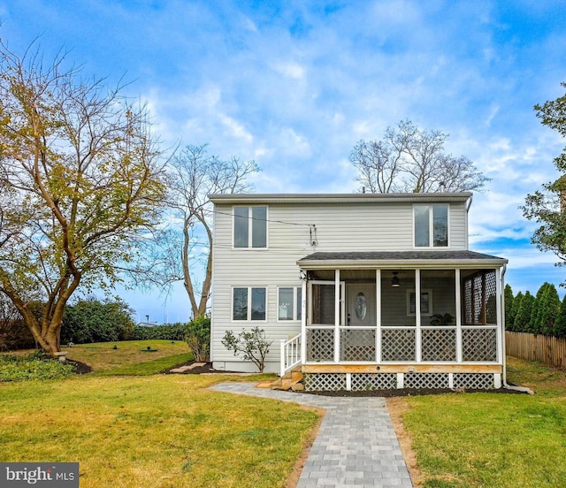 view of front of house with a sunroom and a front lawn