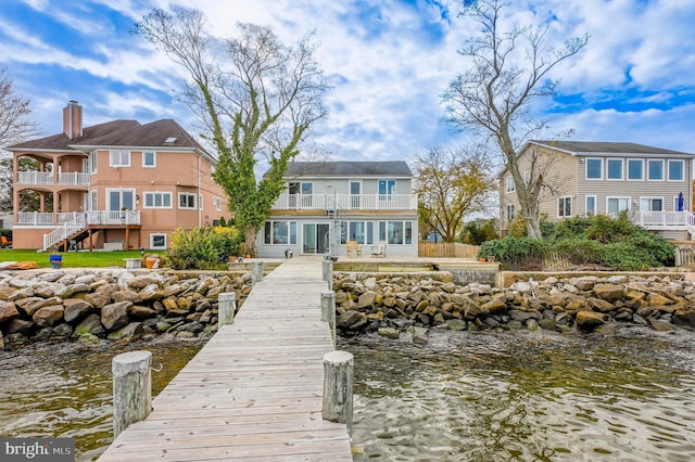 dock area with a water view and a balcony