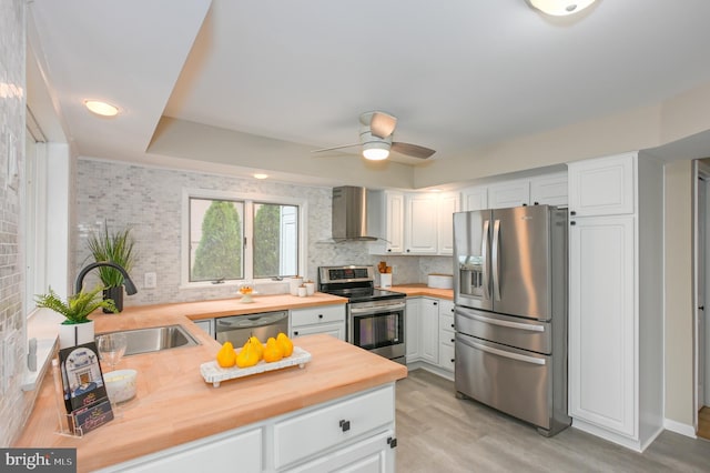 2142 Lake Dr, Pasadena, MD 21122 - kitchen featuring stainless steel appliances, butcher block countertops, wall chimney range hood, a sink, and ceiling fan
