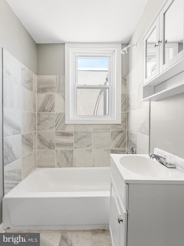 bathroom with vanity, tile walls, and shower / bath combination