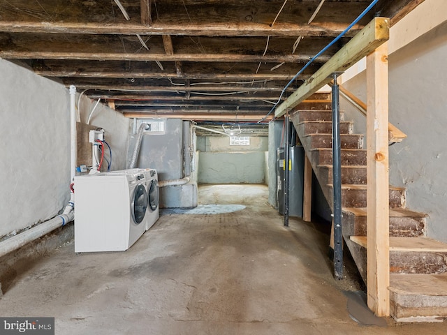 basement with electric water heater and separate washer and dryer