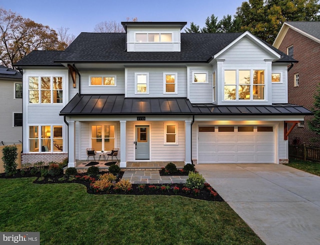 modern farmhouse style home with a yard, a porch, and a garage