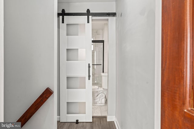 hallway with hardwood / wood-style floors and a barn door