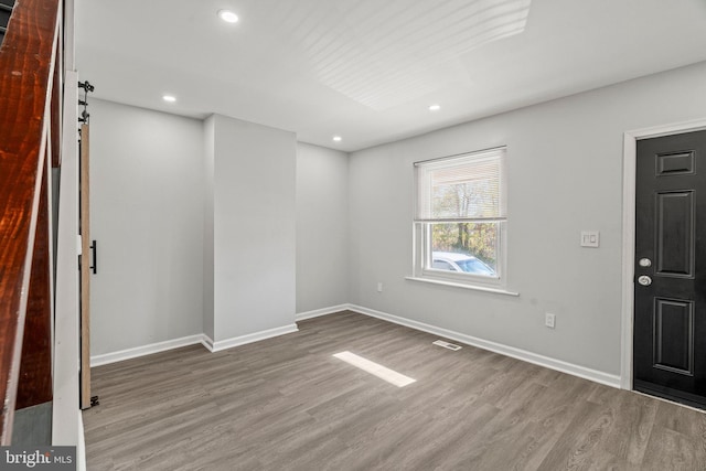 interior space with hardwood / wood-style flooring and a barn door