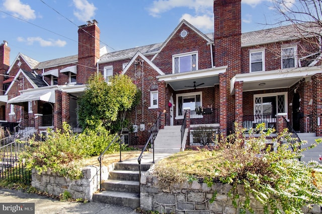 view of front of property with brick siding, a chimney, and a porch