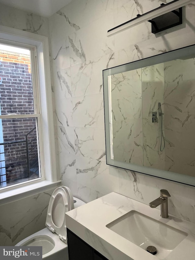 bathroom with vanity, tile walls, and toilet