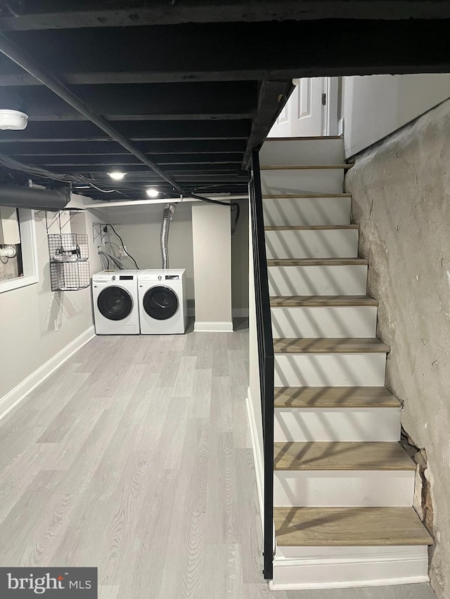 basement featuring washing machine and dryer and wood-type flooring